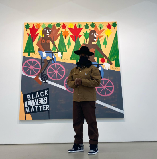 Nina Chanel Abney standing in front of the artwork Being Mixie with my Fixie from 2020. Source: Instagram of the artist